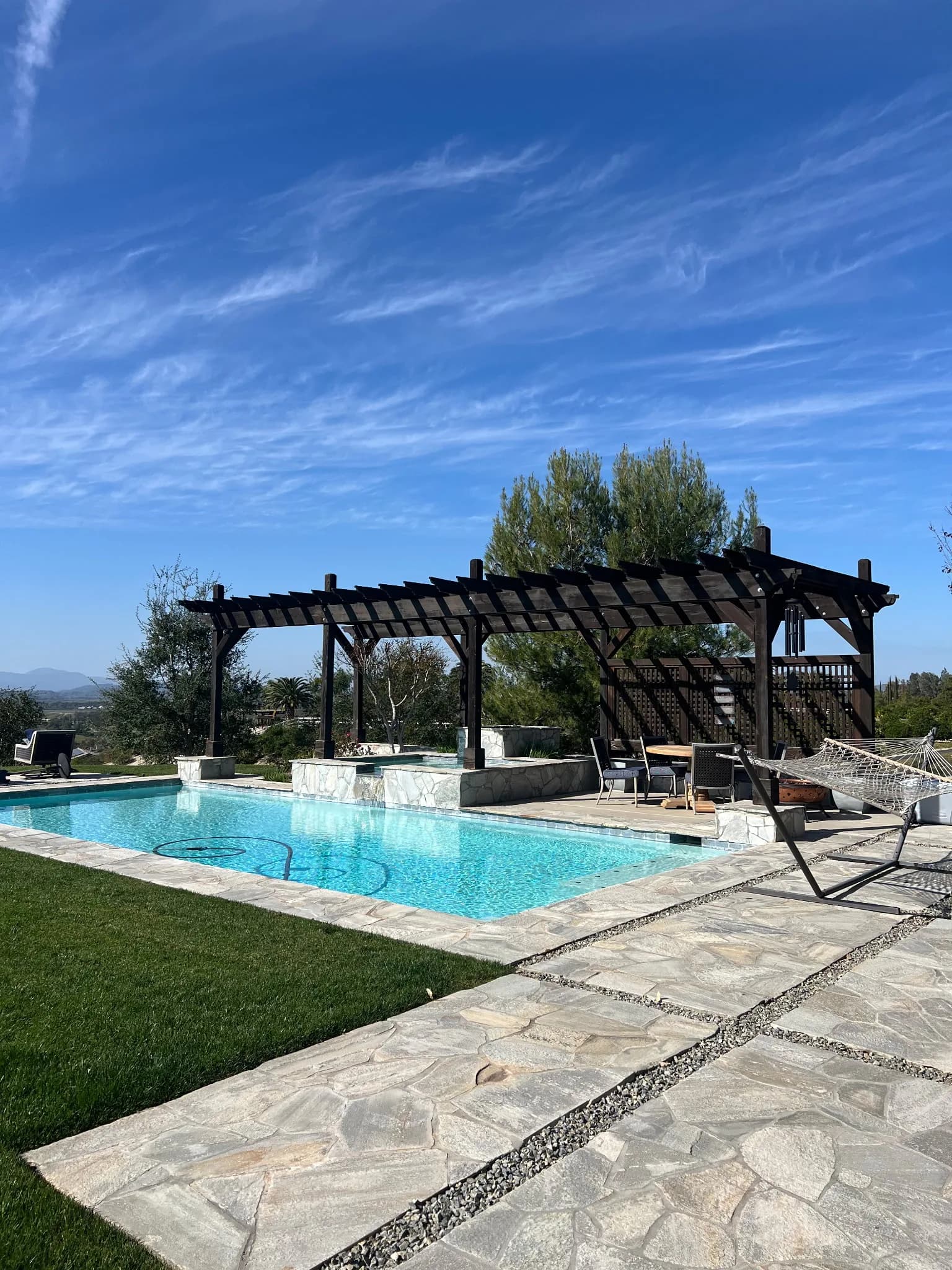 Stained dark wood pergola over poolside, finished